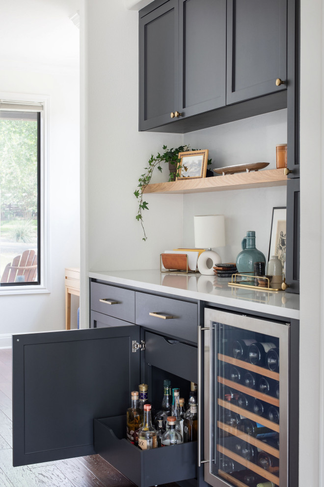 Example of a mid-sized transitional single-wall medium tone wood floor and brown floor dry bar design in Austin with an undermount sink, shaker cabinets, quartz countertops, white countertops and blue cabinets