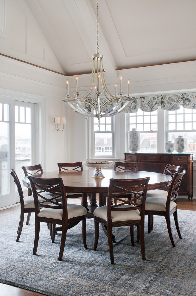 Transitional separate dining room in Philadelphia with white walls, medium hardwood floors, no fireplace, brown floor, vaulted and panelled walls.