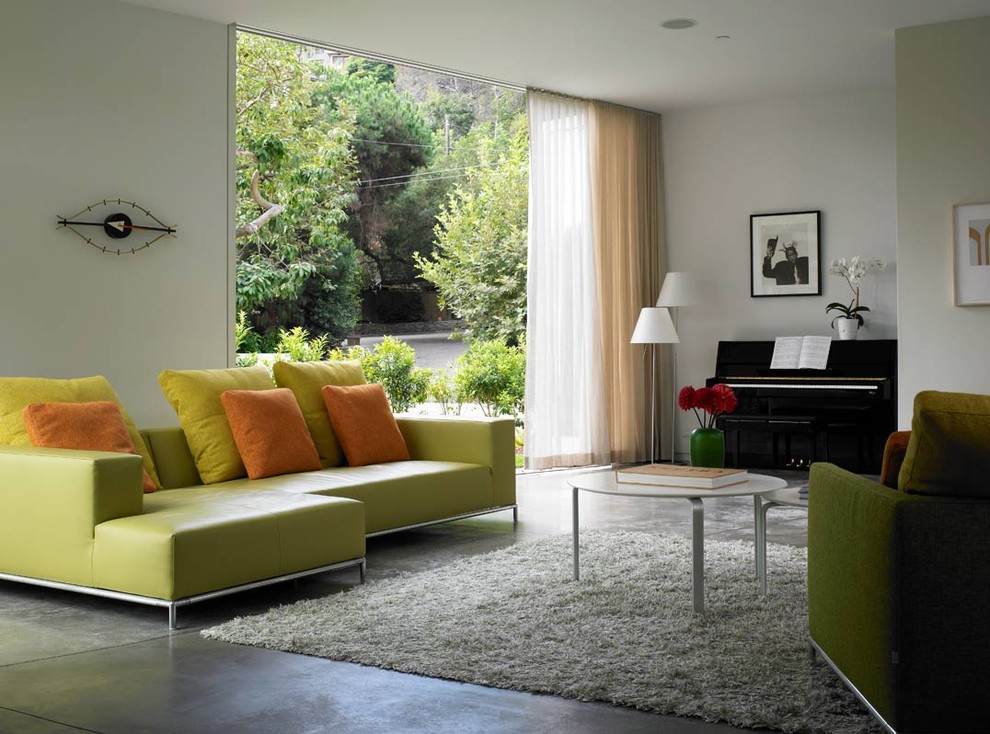 Photo of a modern living room in Los Angeles with a music area and concrete floors.