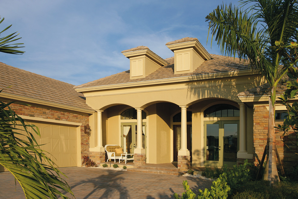 Large country one-storey brick beige exterior in Miami with a hip roof.