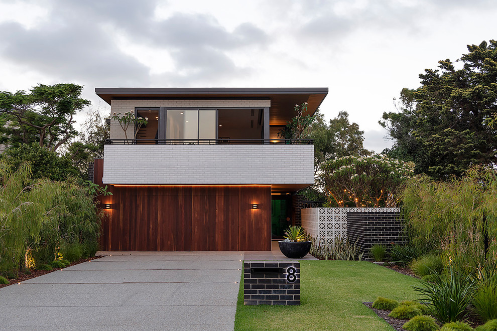 Photo of a large midcentury two-storey house exterior in Perth with wood siding and a flat roof.