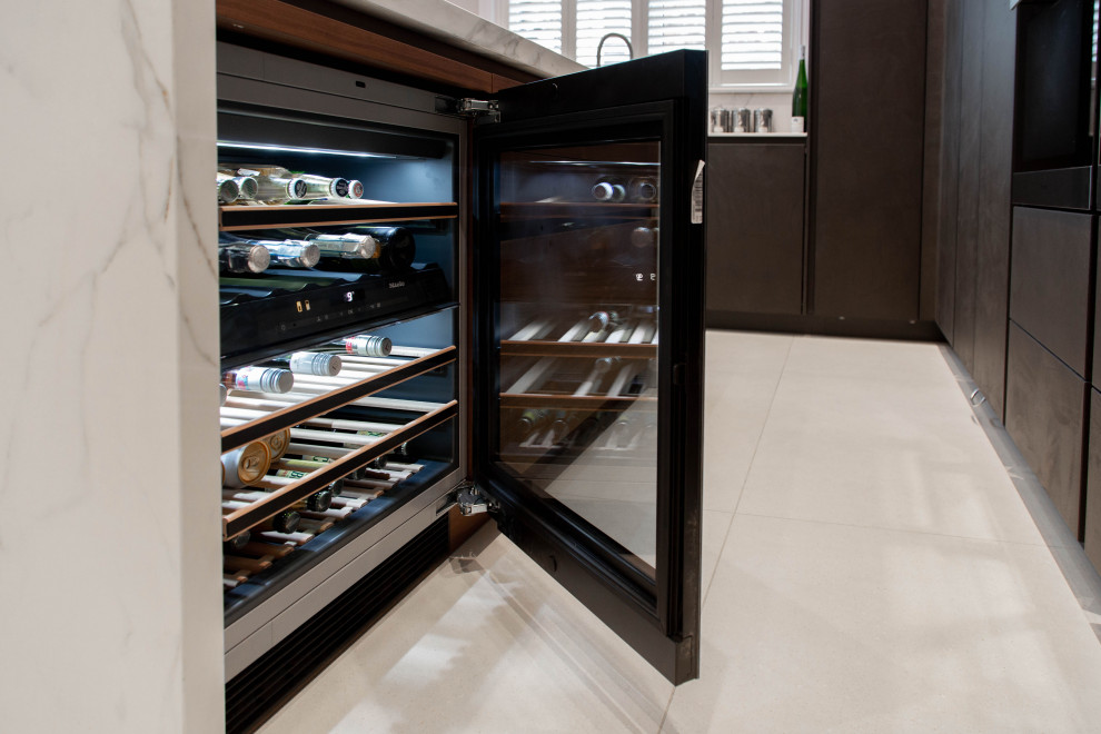 This is an example of a small contemporary l-shaped separate kitchen in London with a drop-in sink, flat-panel cabinets, black cabinets, panelled appliances, ceramic floors, a peninsula, beige floor, white benchtop and coffered.