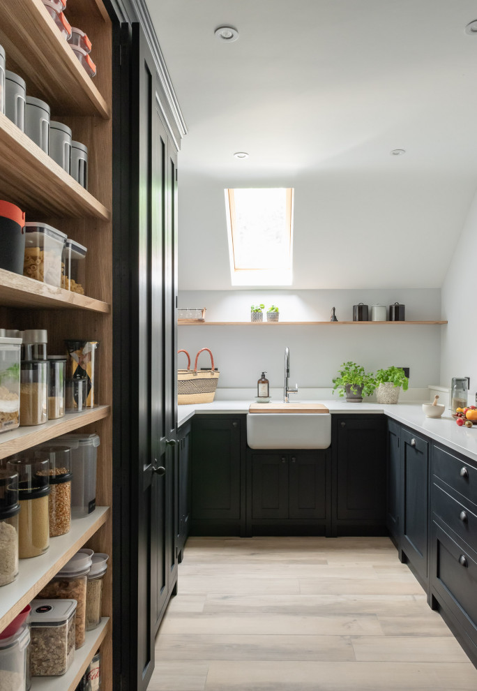 Large traditional u-shaped eat-in kitchen in Surrey with a farmhouse sink, shaker cabinets, black cabinets, quartzite benchtops, white splashback, ceramic splashback, black appliances, ceramic floors, with island and white benchtop.