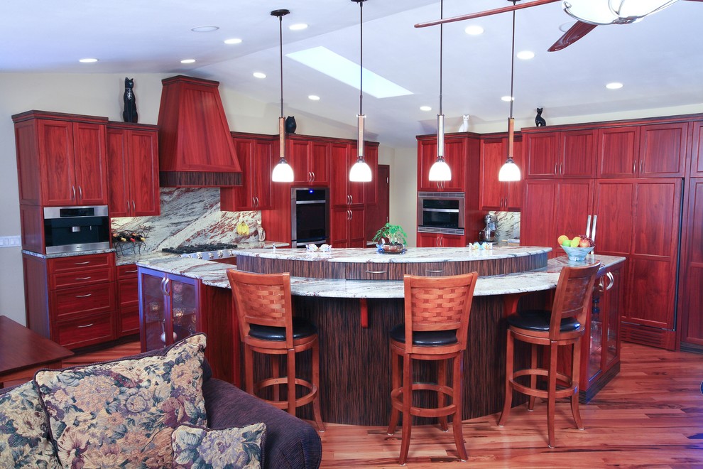 Mid-sized transitional l-shaped medium tone wood floor and brown floor open concept kitchen photo in Seattle with an undermount sink, recessed-panel cabinets, medium tone wood cabinets, granite countertops, gray backsplash, stone slab backsplash, stainless steel appliances and an island