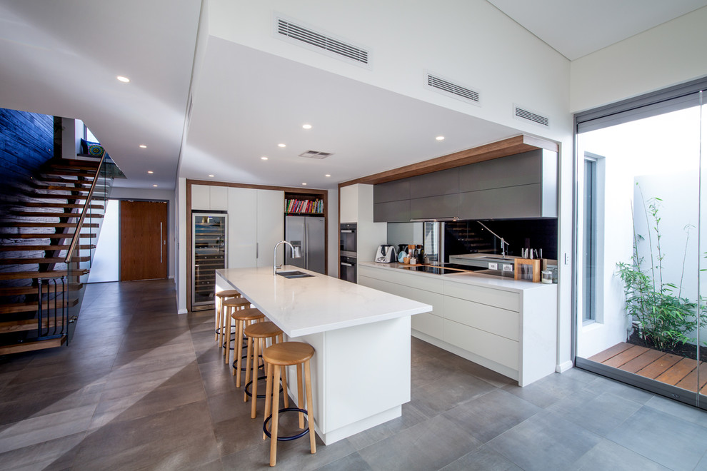 Design ideas for a mid-sized contemporary u-shaped eat-in kitchen in Perth with an undermount sink, quartz benchtops, mirror splashback, black appliances and with island.