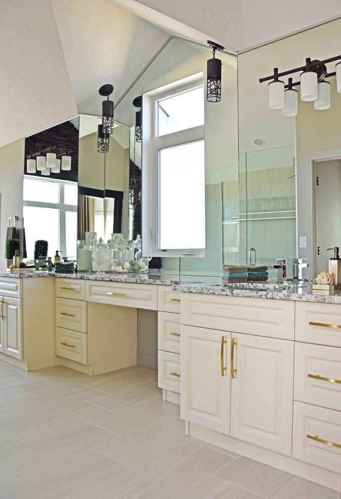 Inspiration for a large transitional master beige tile and porcelain tile porcelain tile and beige floor corner shower remodel in Edmonton with raised-panel cabinets, beige cabinets, beige walls, an undermount sink, granite countertops, a hinged shower door and multicolored countertops