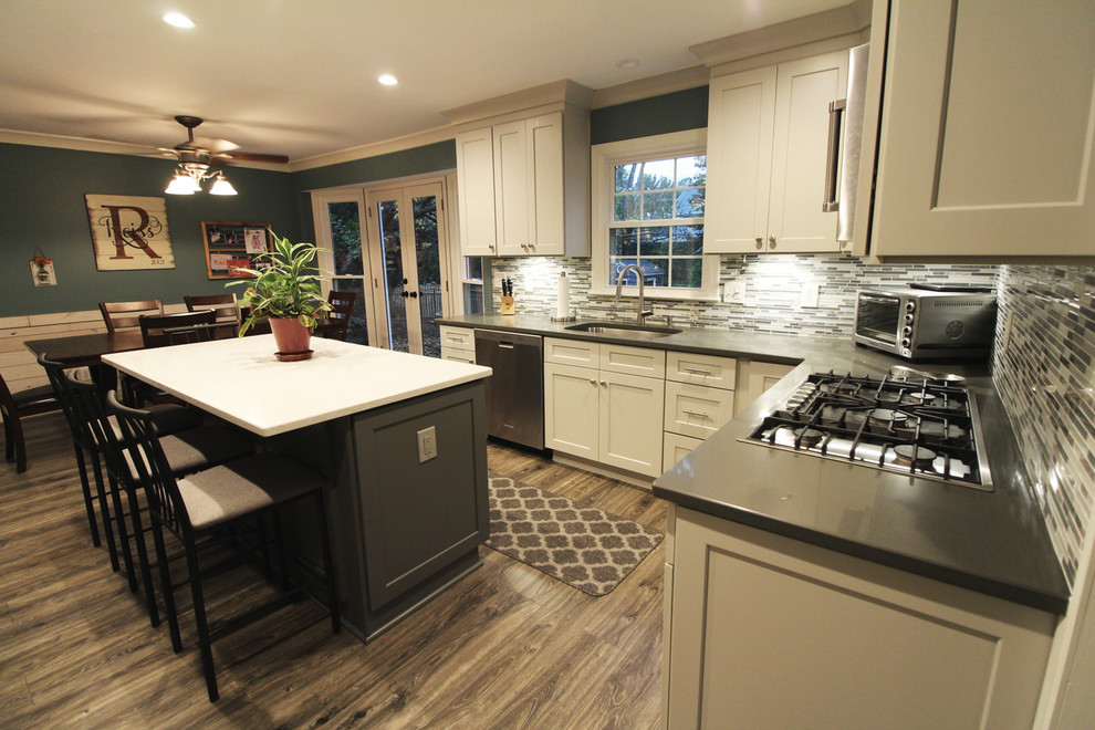 Inspiration for a mid-sized transitional u-shaped medium tone wood floor and brown floor eat-in kitchen remodel in Atlanta with a drop-in sink, white cabinets, granite countertops, gray backsplash, matchstick tile backsplash, stainless steel appliances, an island, shaker cabinets and gray countertops