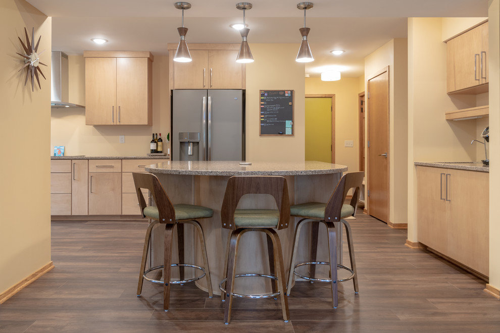 Photo of a transitional eat-in kitchen in Other with an undermount sink, flat-panel cabinets, light wood cabinets, quartzite benchtops, stainless steel appliances, vinyl floors, with island, brown floor and beige benchtop.