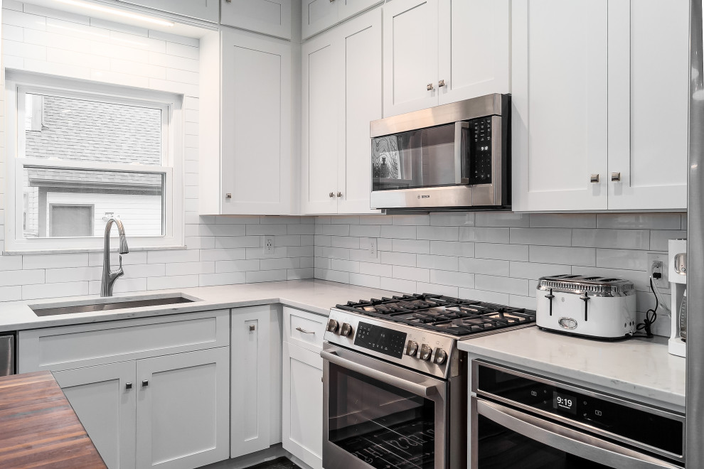 Eat-in kitchen - mid-sized transitional l-shaped eat-in kitchen idea in Columbus with shaker cabinets, quartz countertops, white backsplash, subway tile backsplash and an island