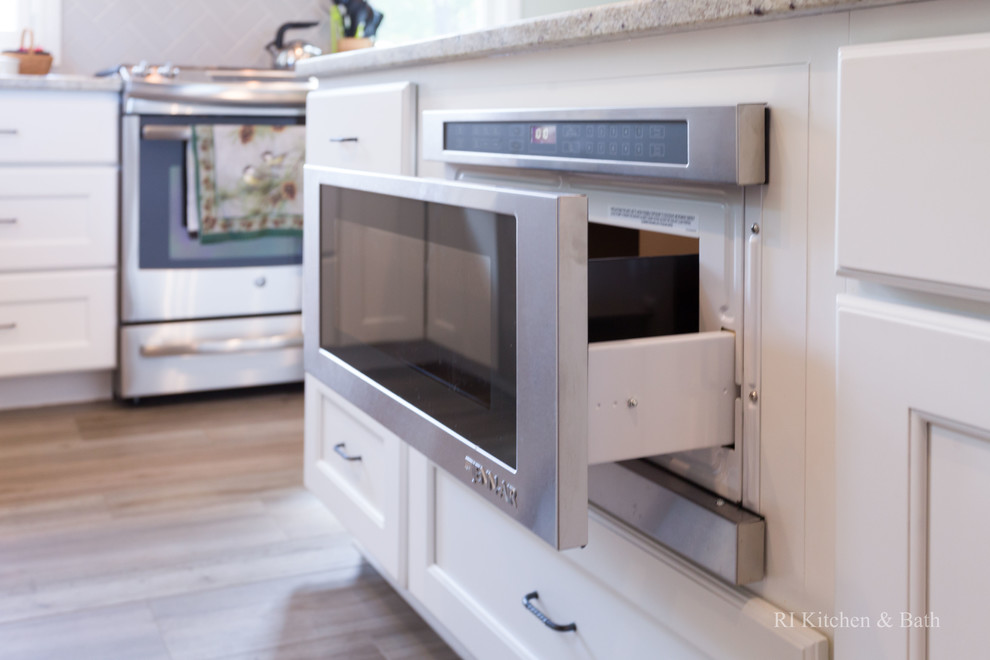 Example of a large transitional l-shaped porcelain tile eat-in kitchen design in Providence with an undermount sink, recessed-panel cabinets, white cabinets, granite countertops, gray backsplash, ceramic backsplash, stainless steel appliances, green walls and an island