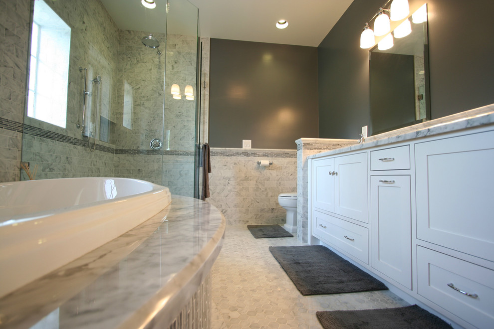 Mid-sized traditional master bathroom in Los Angeles with an undermount sink, shaker cabinets, white cabinets, marble benchtops, a drop-in tub, a corner shower, a two-piece toilet, white tile, subway tile, grey walls and marble floors.