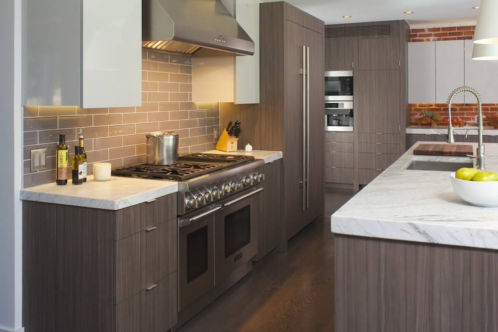 Open concept kitchen - transitional galley dark wood floor open concept kitchen idea in Denver with flat-panel cabinets, brown cabinets, marble countertops, glass tile backsplash, paneled appliances and an island