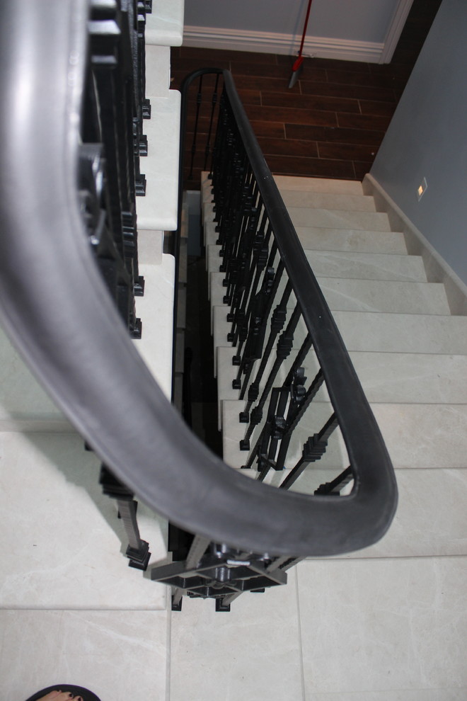 Design ideas for a large transitional marble staircase in Other with marble risers and metal railing.