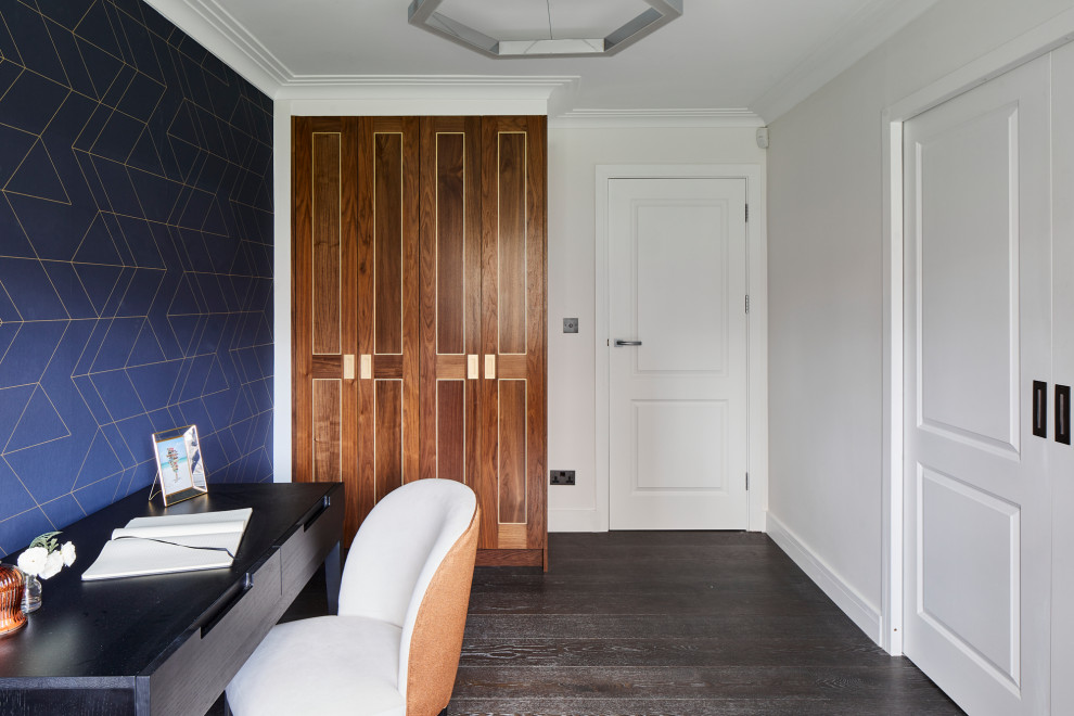 Mittelgroßes Modernes Arbeitszimmer mit blauer Wandfarbe, dunklem Holzboden, freistehendem Schreibtisch, schwarzem Boden und Tapetenwänden in London