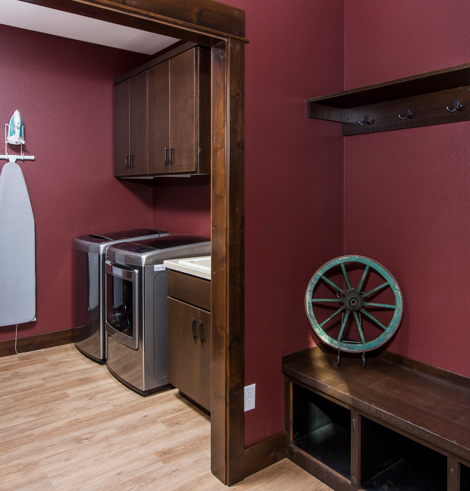 Inspiration for a country single-wall laundry room in Other with a drop-in sink, flat-panel cabinets, dark wood cabinets, red walls, light hardwood floors and a side-by-side washer and dryer.