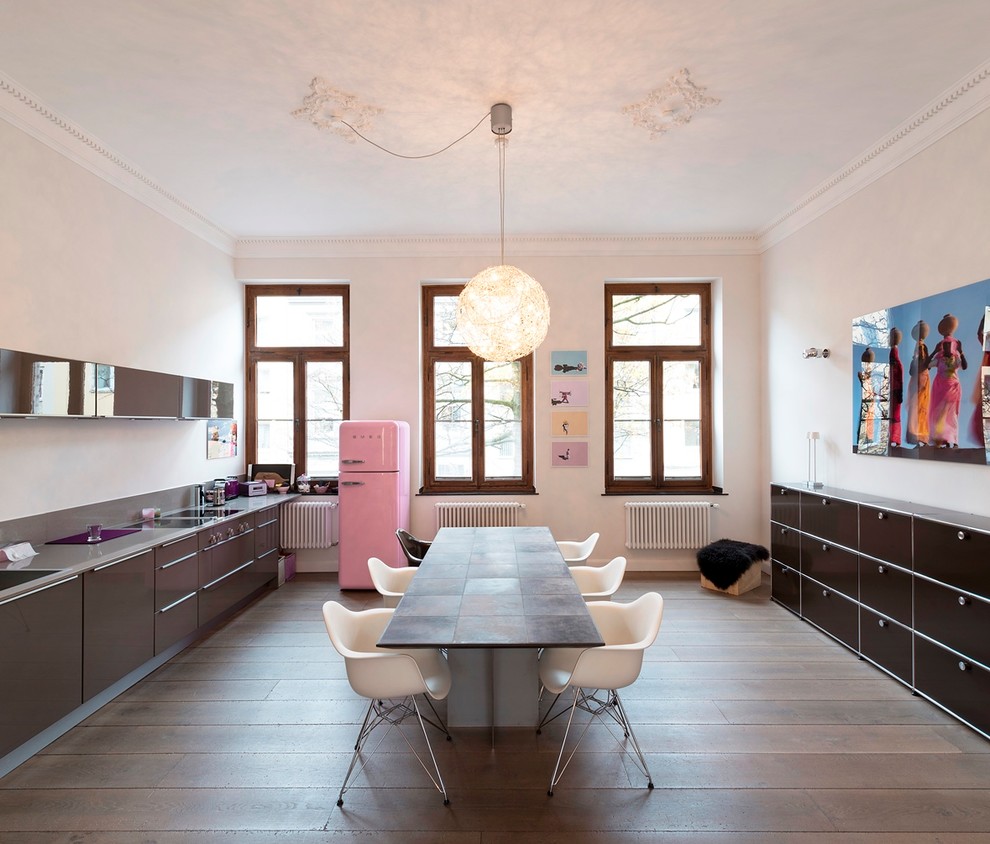 Design ideas for a large eclectic single-wall eat-in kitchen in Dusseldorf with medium hardwood floors, a drop-in sink, flat-panel cabinets, brown cabinets, white splashback, panelled appliances and no island.