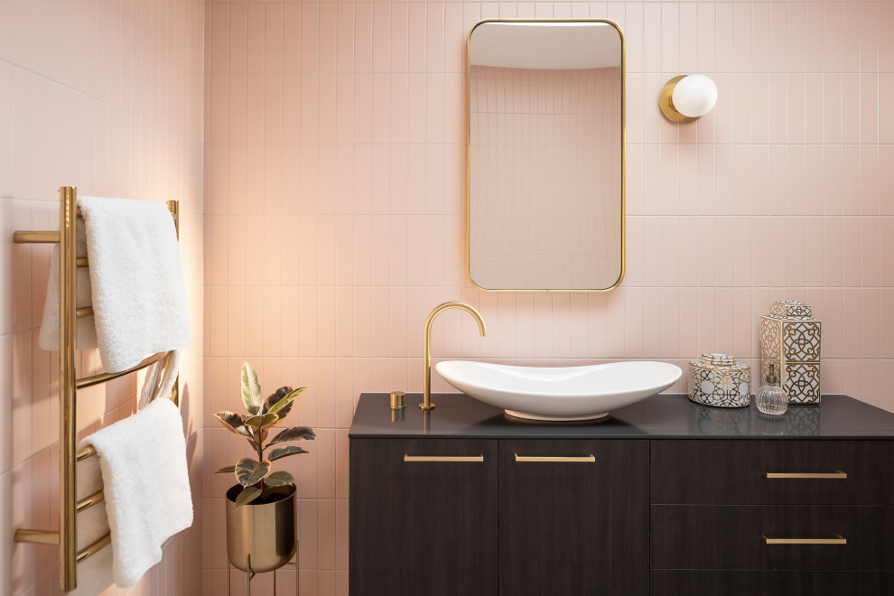 Inspiration for a mid-sized modern 3/4 bathroom in Brisbane with a floating vanity, furniture-like cabinets, dark wood cabinets, a freestanding tub, a one-piece toilet, pink tile, matchstick tile, a vessel sink, laminate benchtops, black benchtops, a single vanity, an open shower, pink walls, an open shower, ceramic floors and grey floor.