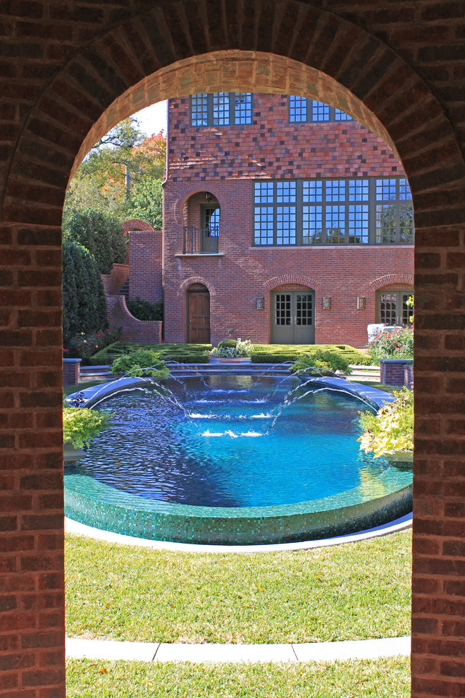 This is an example of a traditional round pool in Dallas with a water feature.