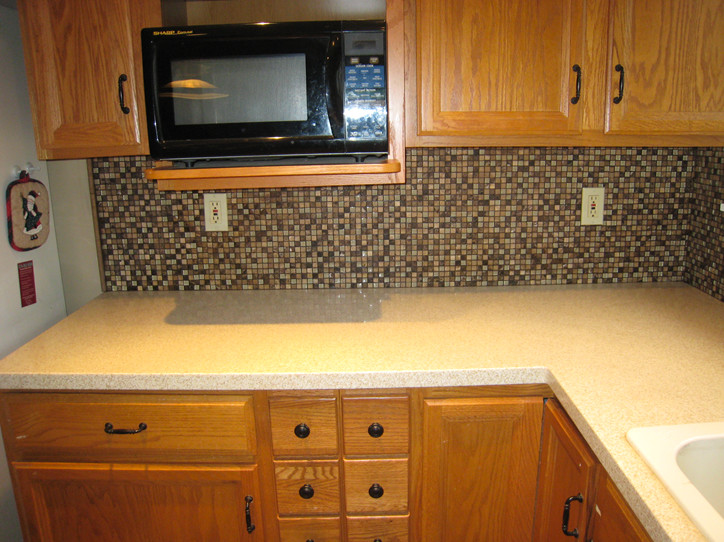 Inspiration for a transitional kitchen remodel in St Louis with a drop-in sink, medium tone wood cabinets, beige backsplash, mosaic tile backsplash, white appliances and no island