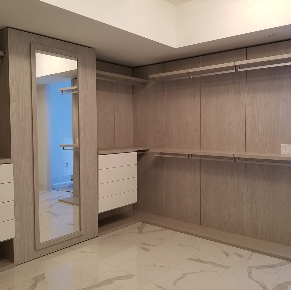 Photo of a large modern gender-neutral walk-in wardrobe in Miami with flat-panel cabinets, dark wood cabinets, marble floors and multi-coloured floor.