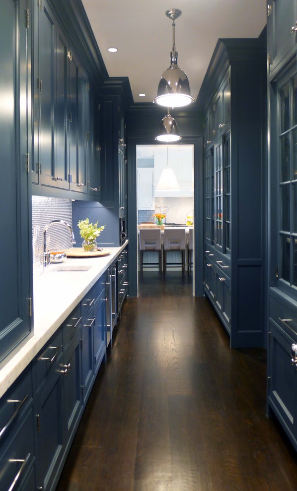 Inspiration for a mid-sized contemporary galley home bar in New York with an undermount sink, recessed-panel cabinets, blue cabinets, quartz benchtops, blue splashback, glass tile splashback, dark hardwood floors, brown floor and white benchtop.