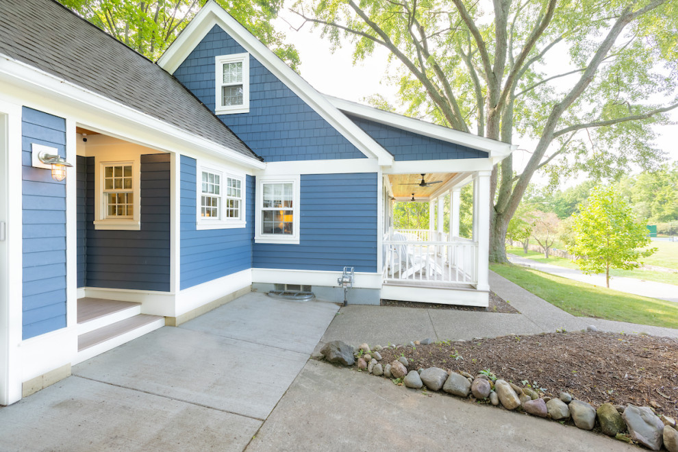 This is an example of a small arts and crafts two-storey blue house exterior in Detroit with concrete fiberboard siding, a gable roof, a tile roof, a grey roof and clapboard siding.