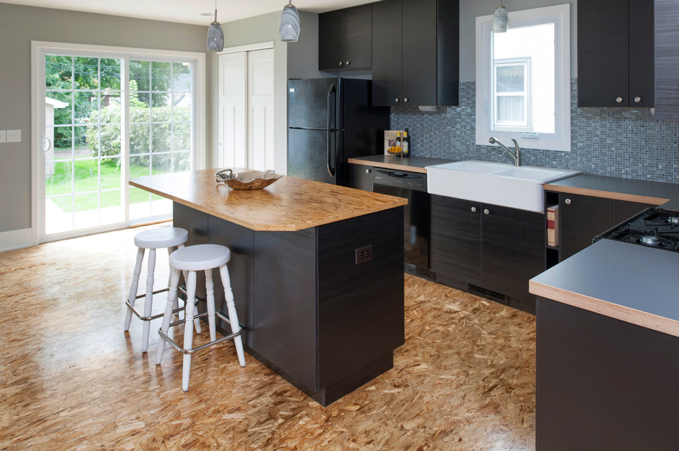 Small modern l-shaped eat-in kitchen in Minneapolis with a farmhouse sink, flat-panel cabinets, dark wood cabinets, laminate benchtops, mosaic tile splashback, black appliances and with island.