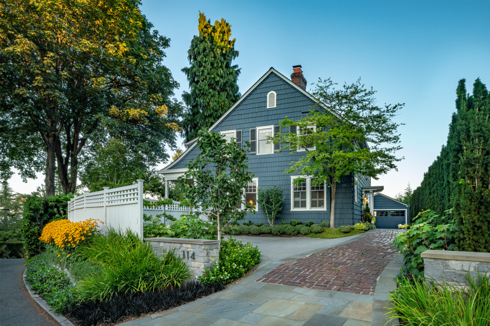 This is an example of a large traditional two-storey blue house exterior in Seattle with wood siding, a gable roof and shingle siding.