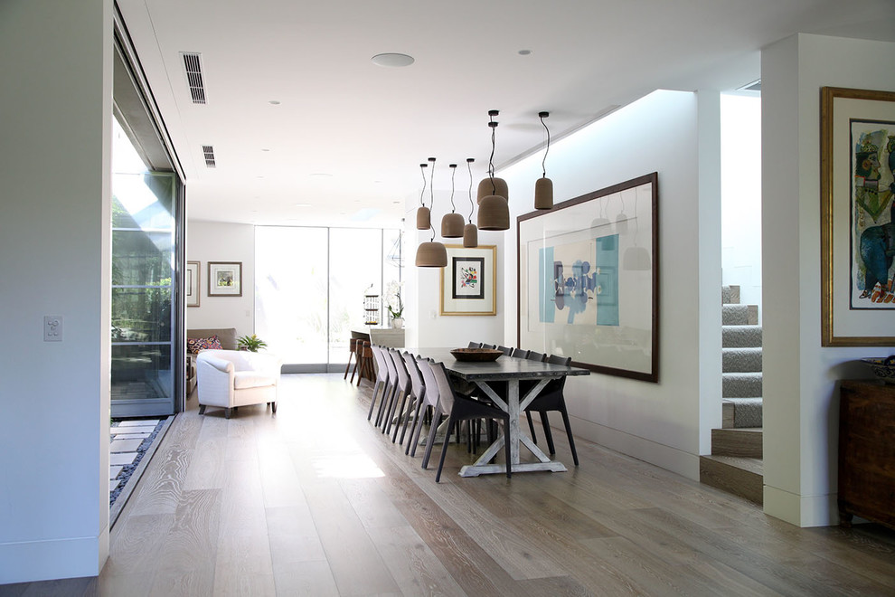 Design ideas for a contemporary dining room in Sydney with white walls and light hardwood floors.