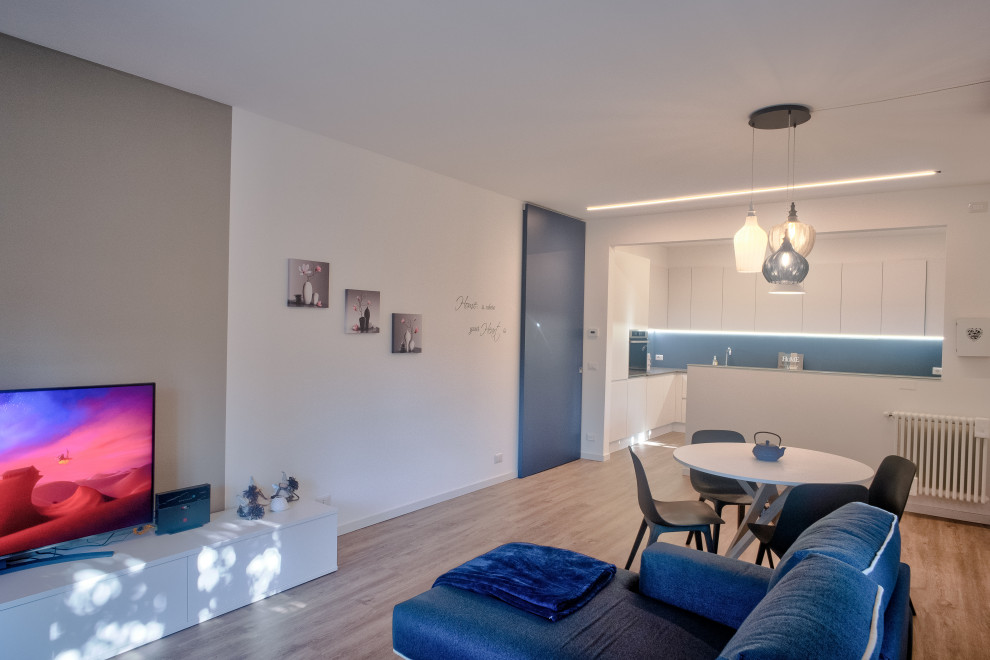 Ispirazione per un soggiorno contemporaneo di medie dimensioni e aperto con pareti beige, pavimento in vinile, TV autoportante e pavimento beige