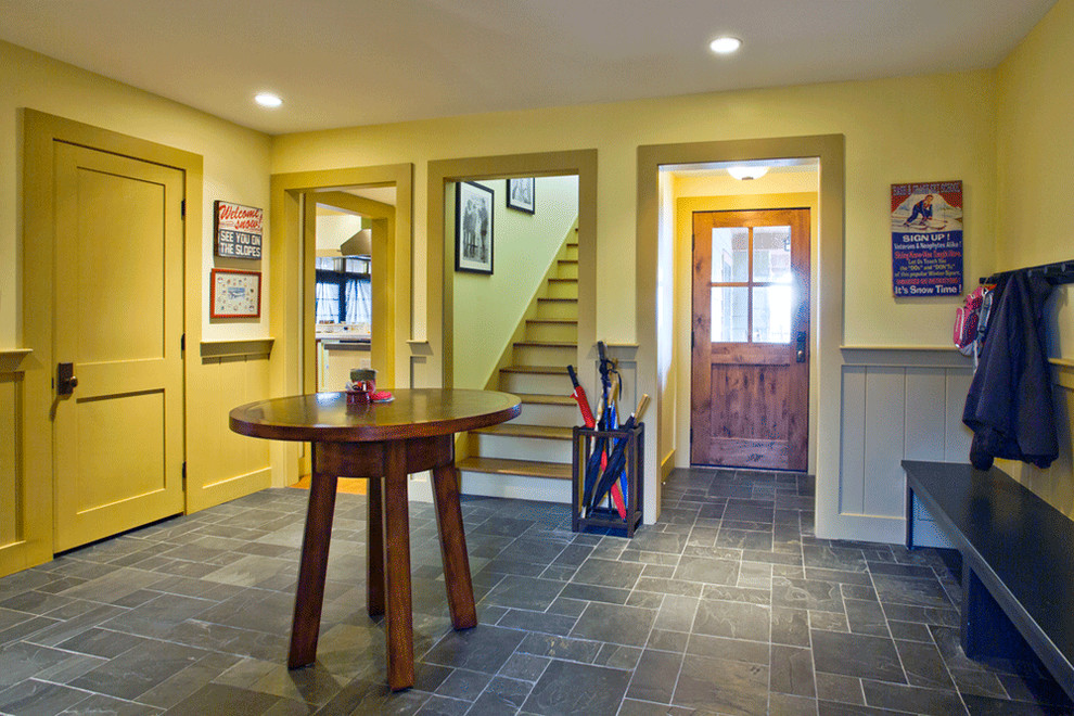 Design ideas for a large arts and crafts foyer in Salt Lake City with yellow walls, slate floors, a single front door and a dark wood front door.