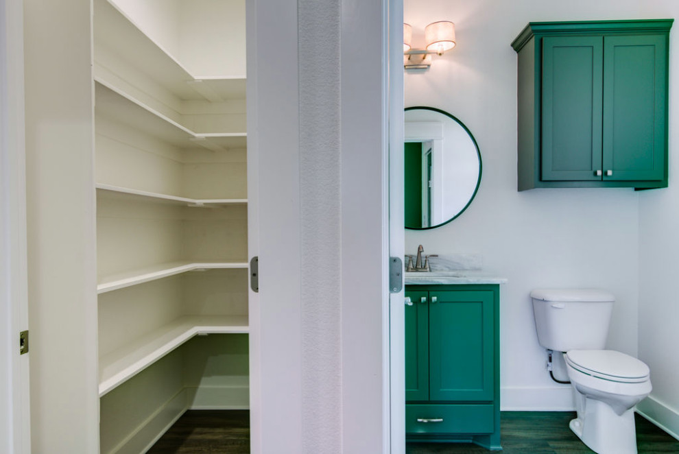 На фото: туалет с любым типом туалета среднего размера с фасадами в стиле шейкер, зелеными фасадами, белыми стенами, полом из винила, врезной раковиной, столешницей из гранита, коричневым полом, разноцветной столешницей, напольной тумбой, любым потолком, любой отделкой стен и плиткой с