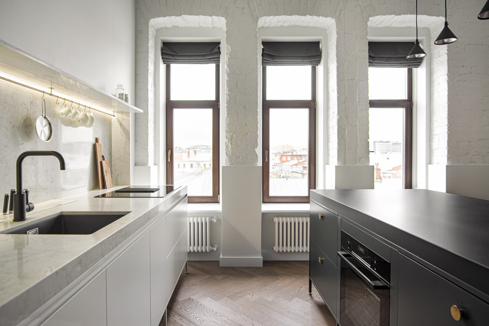 Diseño de cocina contemporánea con puertas de armario blancas y suelo de madera clara