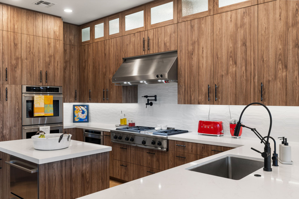 Enclosed kitchen - rustic l-shaped slate floor and beige floor enclosed kitchen idea with a single-bowl sink, flat-panel cabinets, medium tone wood cabinets, quartzite countertops, white backsplash, glass sheet backsplash, stainless steel appliances, a peninsula and white countertops