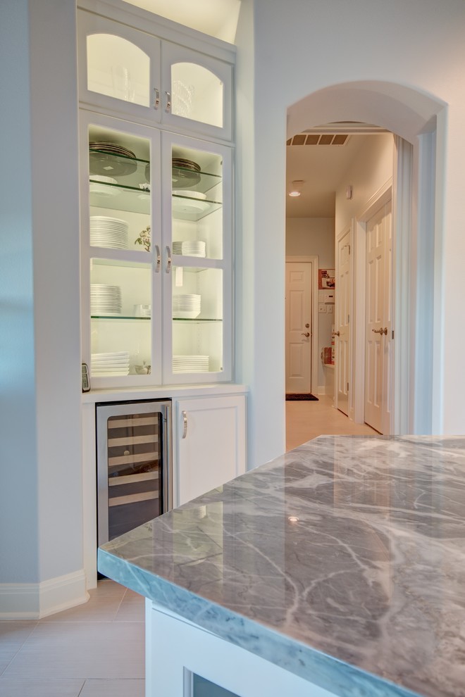 Large transitional u-shaped porcelain tile eat-in kitchen photo in Austin with recessed-panel cabinets, white cabinets, marble countertops, gray backsplash, stainless steel appliances and an island