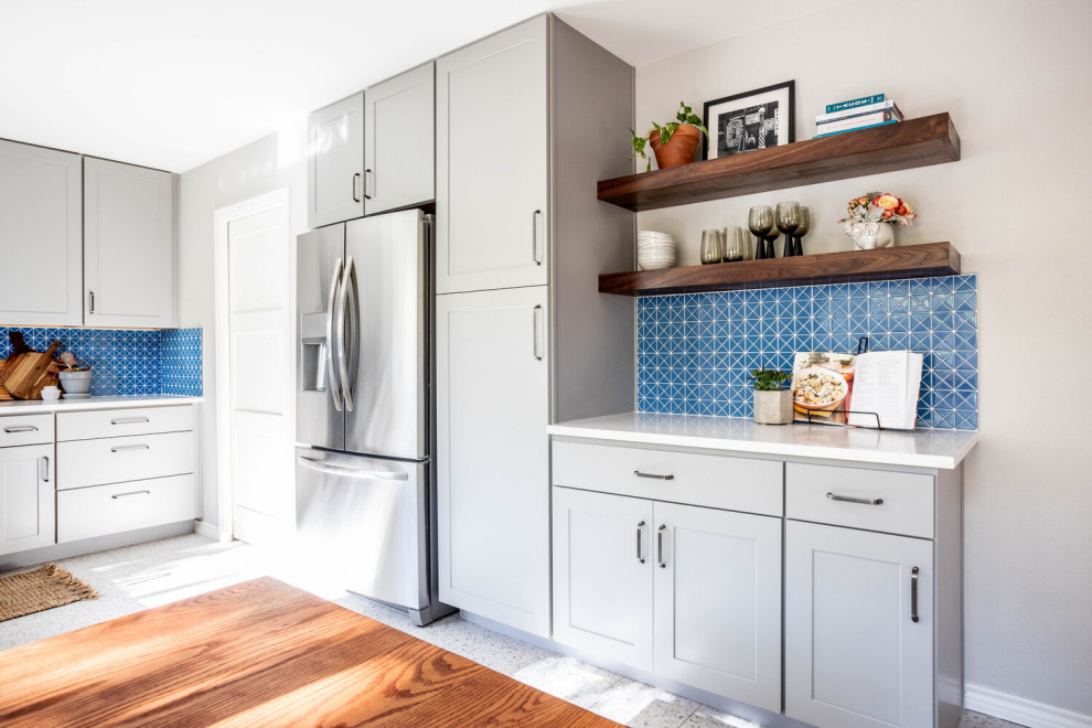Example of a mid-sized transitional l-shaped multicolored floor enclosed kitchen design in Austin with an undermount sink, shaker cabinets, gray cabinets, quartz countertops, blue backsplash, ceramic backsplash, stainless steel appliances, no island and white countertops