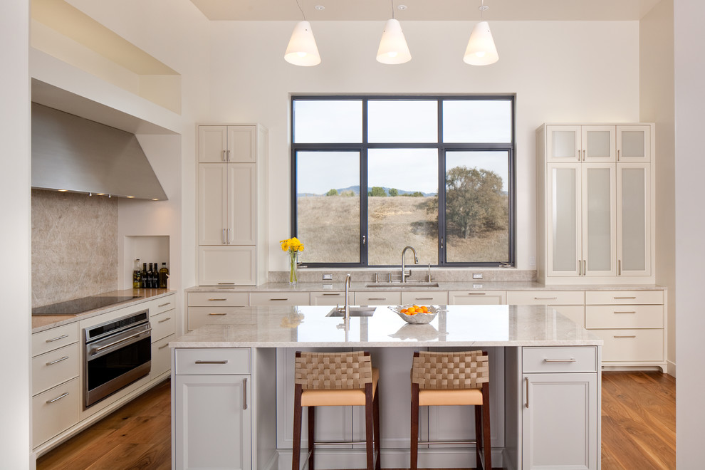 Inspiration for a traditional l-shaped kitchen in Santa Barbara with recessed-panel cabinets, white cabinets and beige splashback.