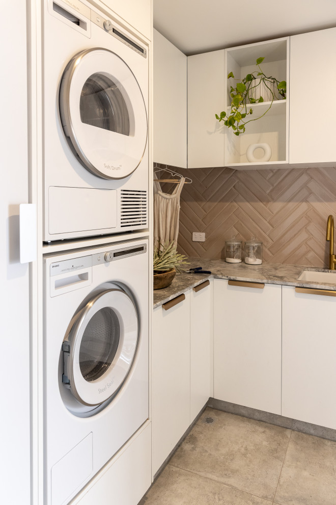 Inspiration för mellanstora moderna flerfärgat tvättstugor enbart för tvätt, med en dubbel diskho, vita skåp, marmorbänkskiva, rosa stänkskydd, stänkskydd i tunnelbanekakel, vita väggar, klinkergolv i porslin och en tvättpelare