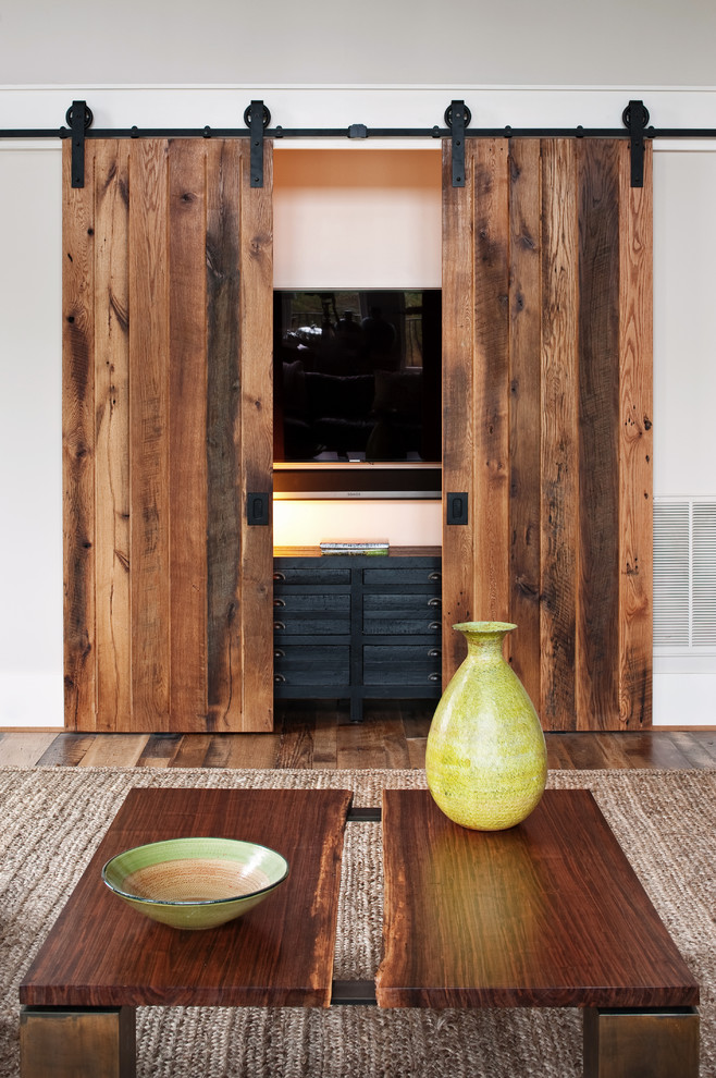 Example of a mountain style medium tone wood floor living room design in Richmond with white walls and a concealed tv