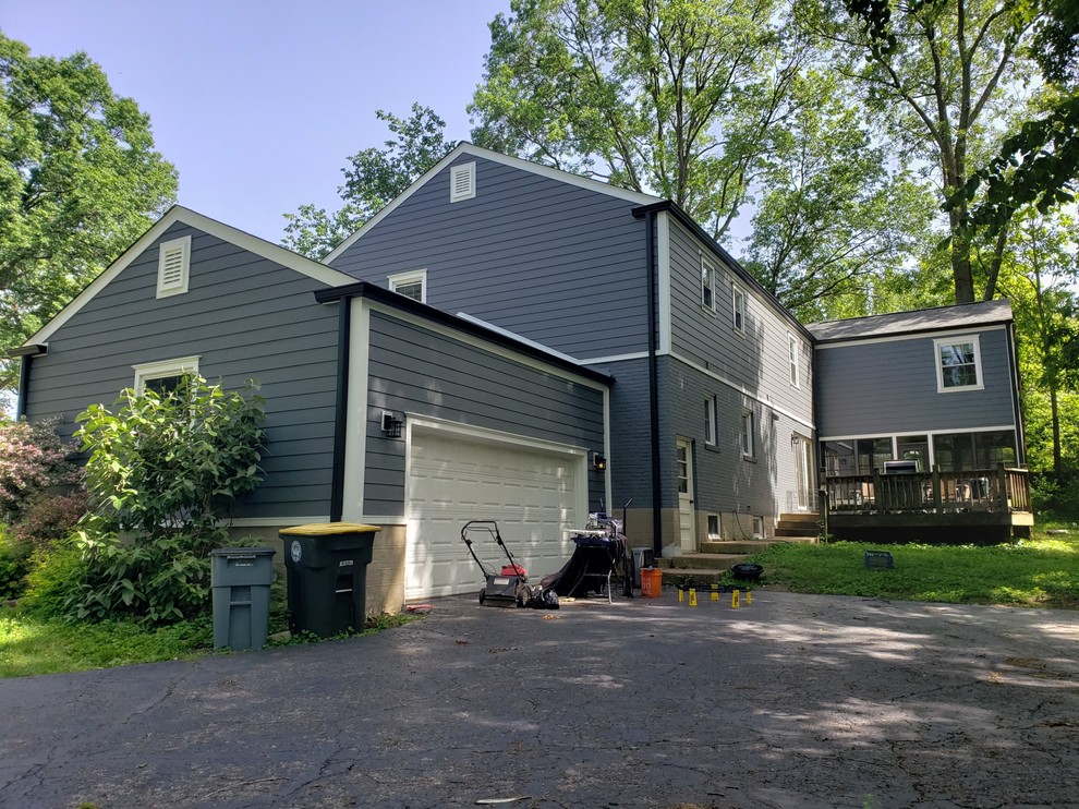 Mid-sized traditional two-storey grey house exterior in St Louis with concrete fiberboard siding, a gable roof and a shingle roof.
