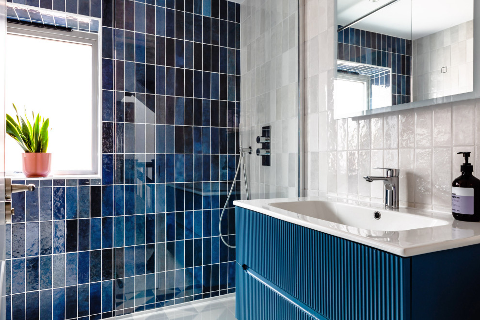 This is an example of a contemporary bathroom in Hertfordshire with flat-panel cabinets, blue cabinets, an alcove shower, blue tiles, a console sink, a single sink and a floating vanity unit.