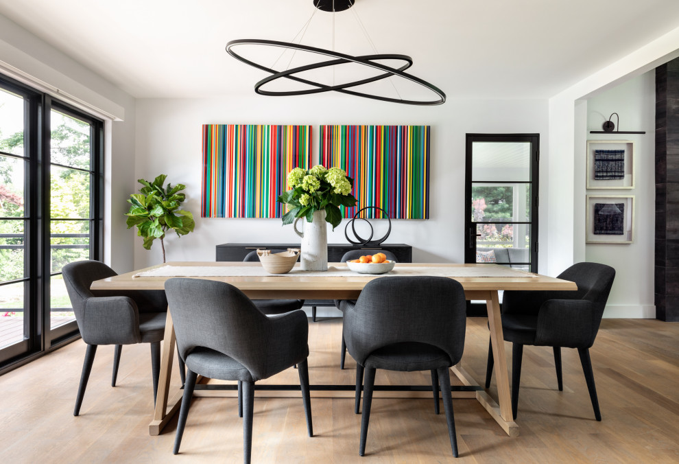 Foto di una sala da pranzo aperta verso la cucina contemporanea di medie dimensioni con pareti grigie, parquet chiaro, nessun camino e pavimento marrone