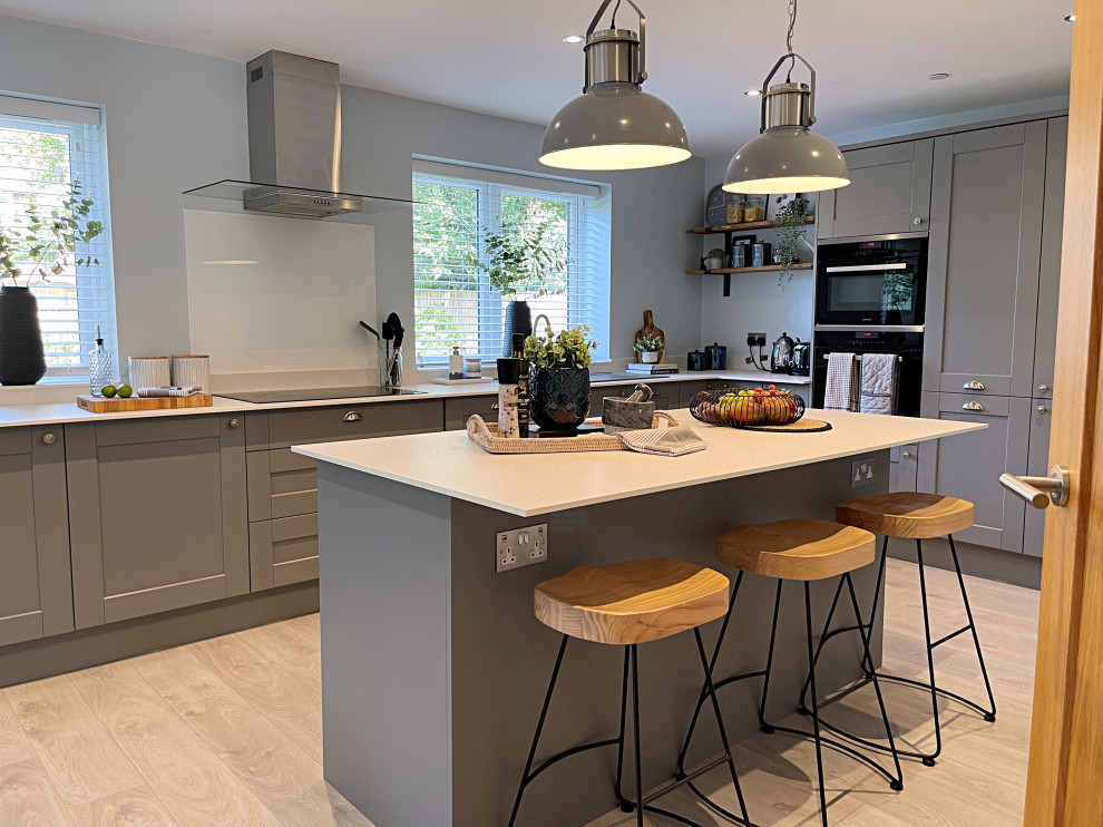 Design ideas for a large eclectic l-shaped open plan kitchen in Hampshire with shaker cabinets, grey cabinets, marble benchtops, ceramic floors, with island, brown floor and white benchtop.