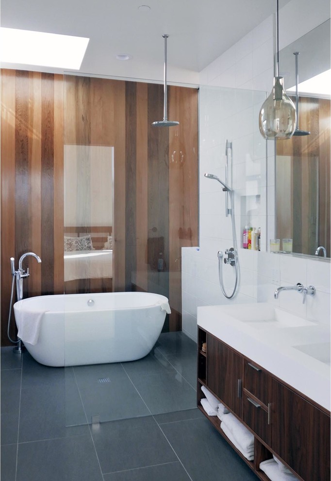 This is an example of a large contemporary master wet room bathroom in Los Angeles with flat-panel cabinets, dark wood cabinets, a freestanding tub, a two-piece toilet, white tile, glass tile, white walls, slate floors, an integrated sink, quartzite benchtops, grey floor and an open shower.