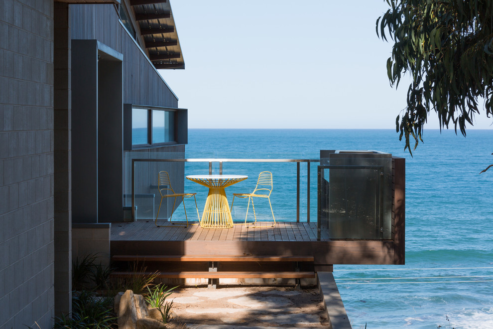 This is an example of a mid-sized beach style balcony in Geelong with glass railing and no cover.