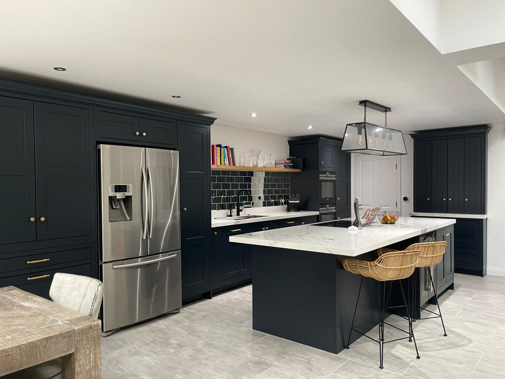 This is an example of a contemporary eat-in kitchen in London with a drop-in sink, shaker cabinets, grey cabinets and with island.