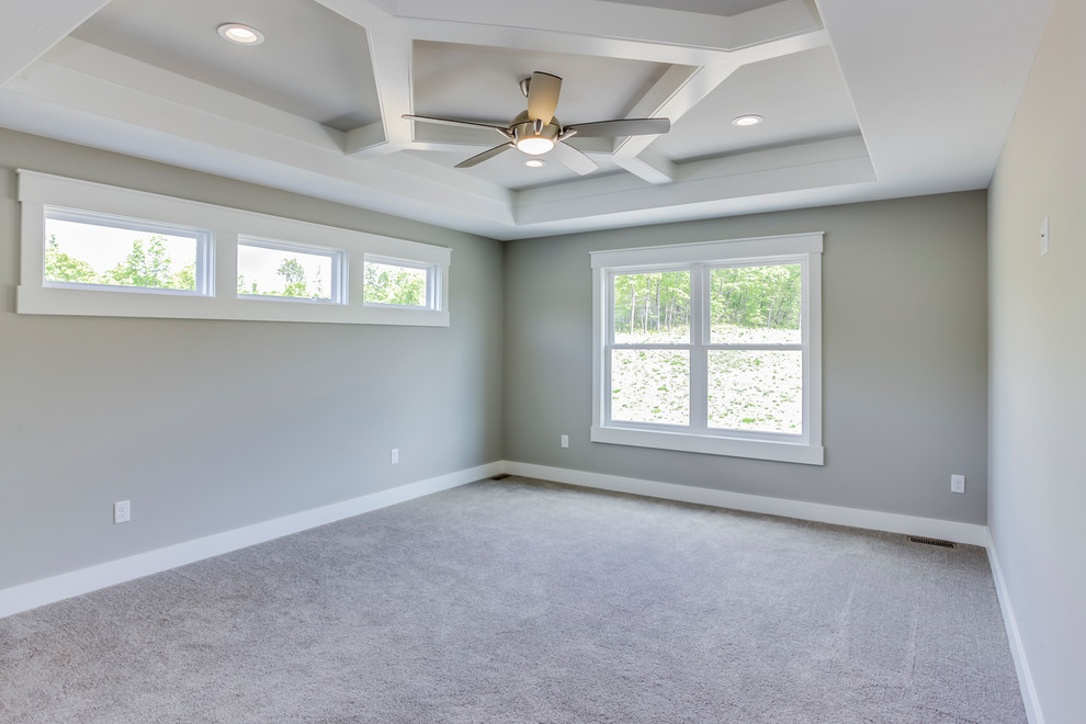 This is an example of a mid-sized arts and crafts master bedroom in Grand Rapids with carpet.