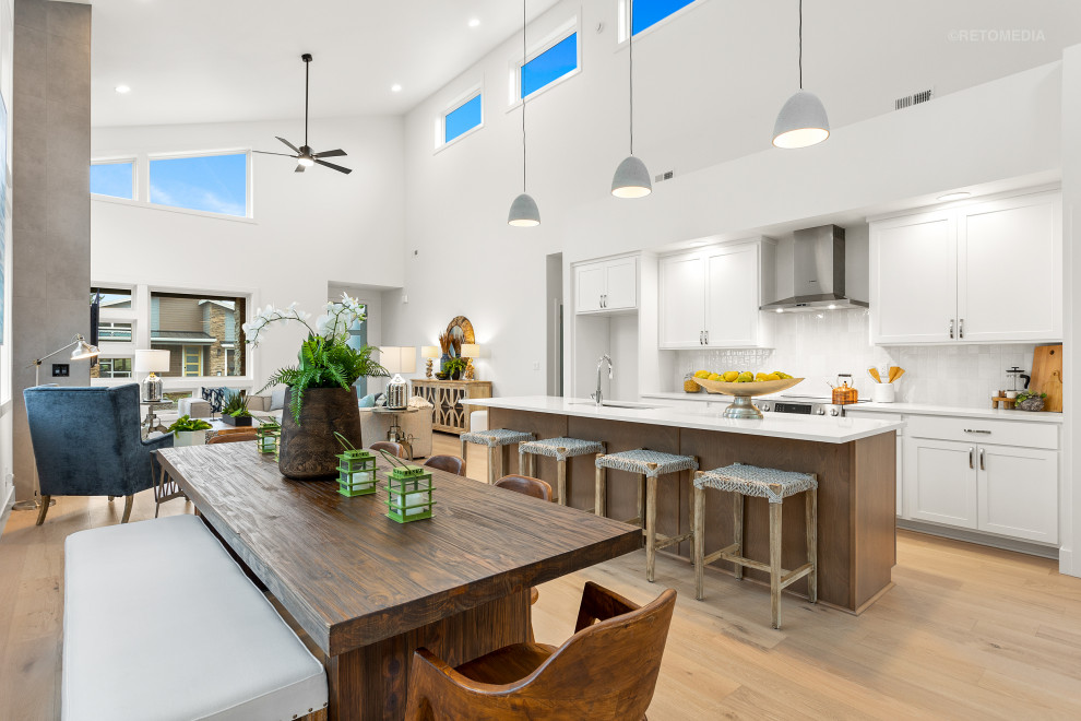 Idee per una sala da pranzo aperta verso la cucina moderna di medie dimensioni con pareti bianche, parquet chiaro, pavimento marrone e soffitto a volta