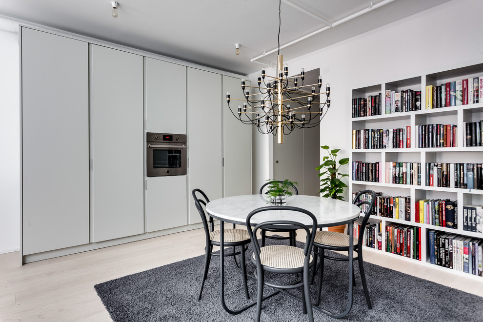 Design ideas for a mid-sized contemporary dining room in Stockholm with white walls and light hardwood floors.