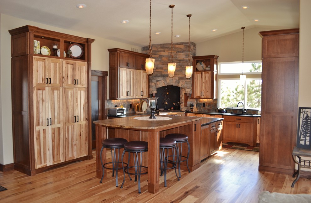Inspiration for a rustic medium tone wood floor eat-in kitchen remodel in Denver with an undermount sink, flat-panel cabinets, light wood cabinets, wood countertops and an island